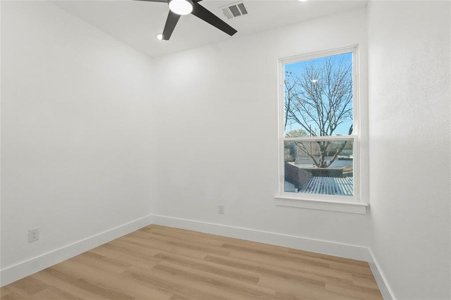 Empty room with light wood finished floors and a ceiling fan