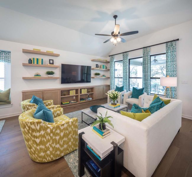 Living room with lofted ceiling, a ceiling fan, dark wood-style flooring, and baseboards