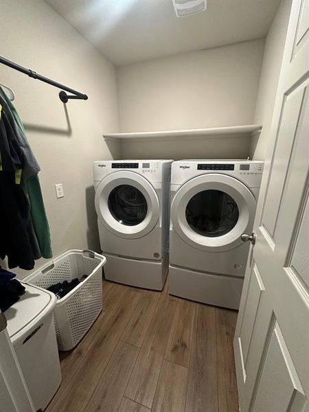 Washroom with light wood finished floors and independent washer and dryer