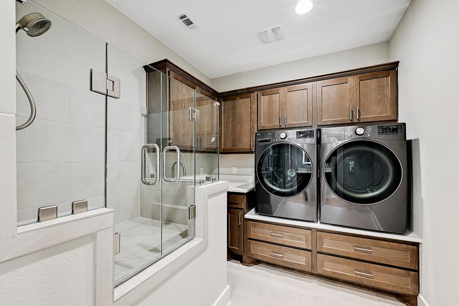 A combination laundry room and glassed in pet-wash area offers practical, space-saving convenience.