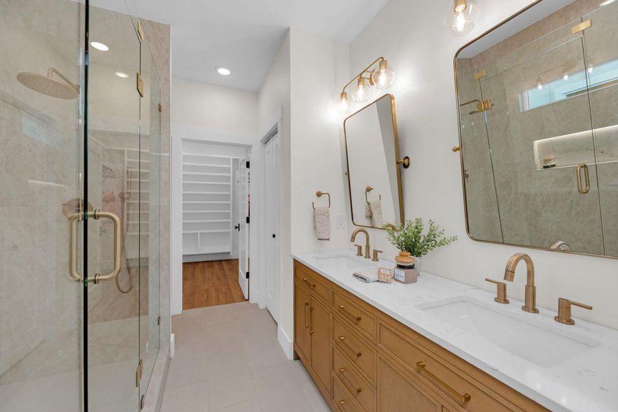 Double vanity, double shower system with LED niche lighting Fully skirted Kohler toilet with elongated bowl.