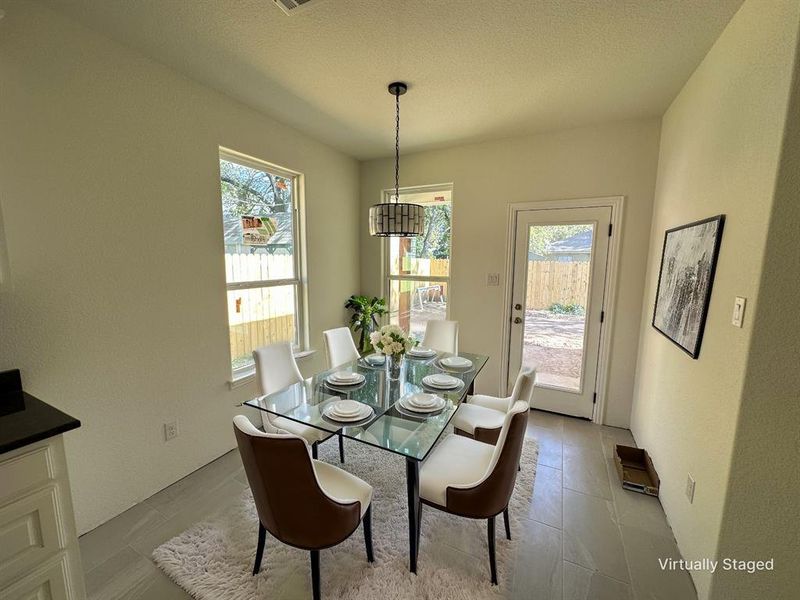 Dining space with light tile patterned floors and plenty of natural light