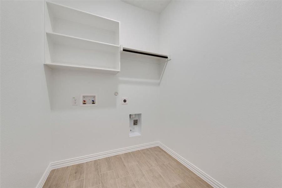 Laundry room with hookup for an electric dryer, washer hookup, light hardwood / wood-style flooring, and hookup for a gas dryer