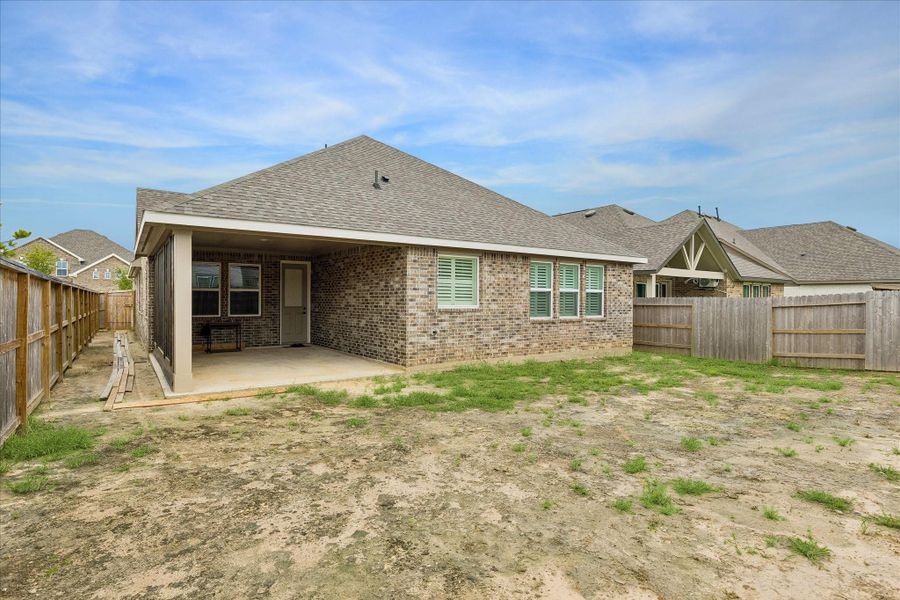 Spacious covered patio extends the living space outdoors, ideal for relaxing evenings, grilling, or future outdoor entertaining.