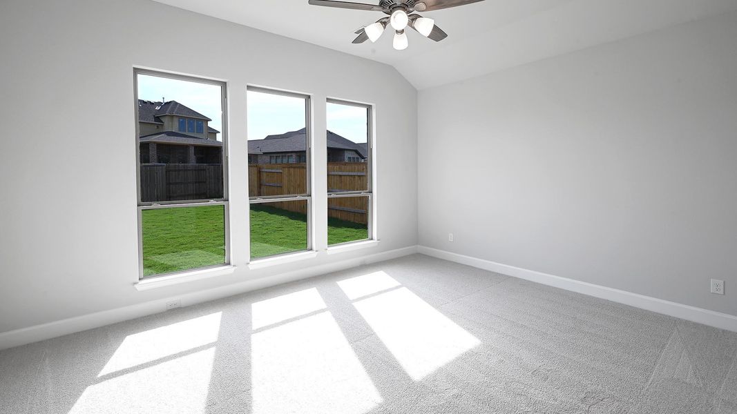 Empty room with carpet floors, ceiling fan, and vaulted ceiling