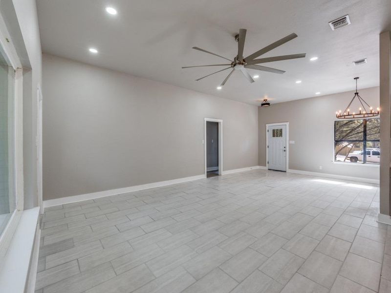 Unfurnished room featuring a ceiling fan and suspended lighting