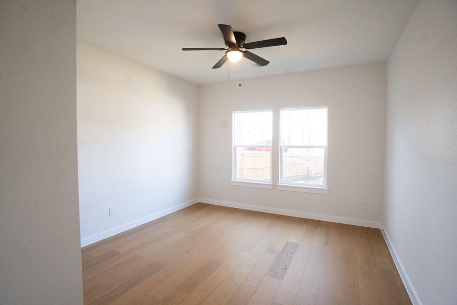 Spare room with light wood finished floors and a ceiling fan