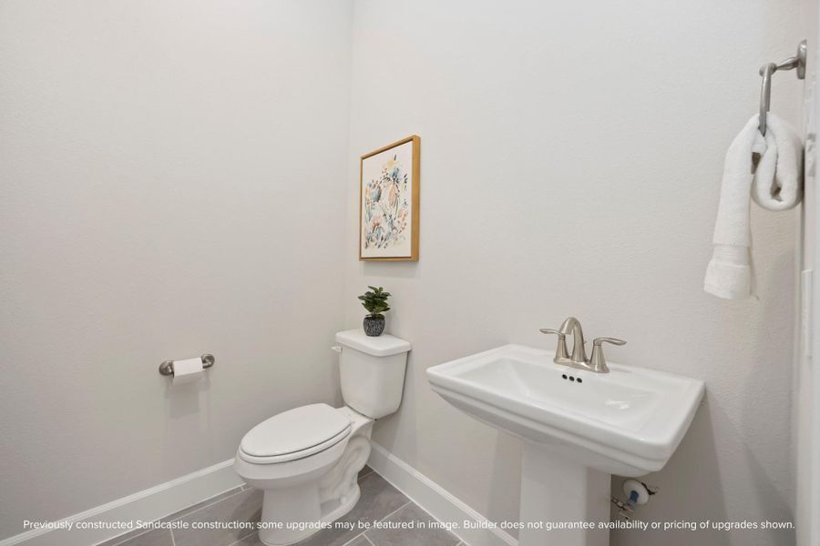 A downstairs retreat featuring a timeless pedestal sink, offering both style and convenience. A downstairs retreat featuring a timeless pedestal sink, offering both style and convenience.