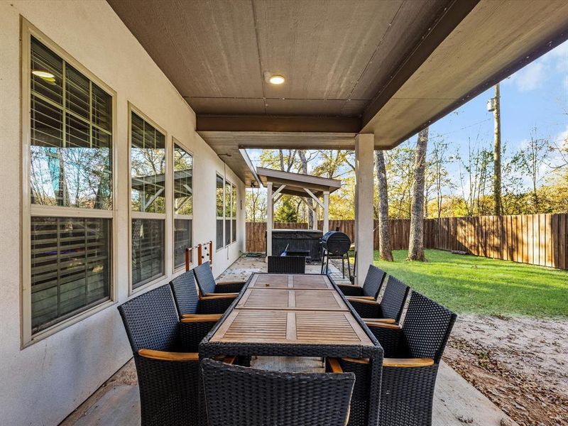Fenced backyard with a patio area, outdoor dining area, grilling area, and a gazebo