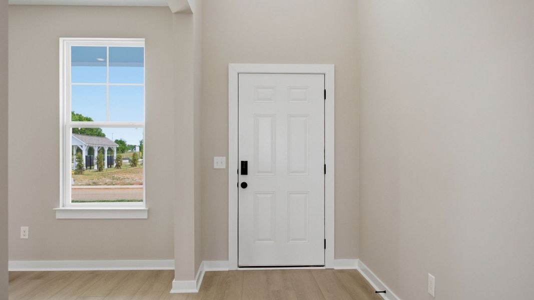 Front door to home with nearby window Front door to home with nearby window