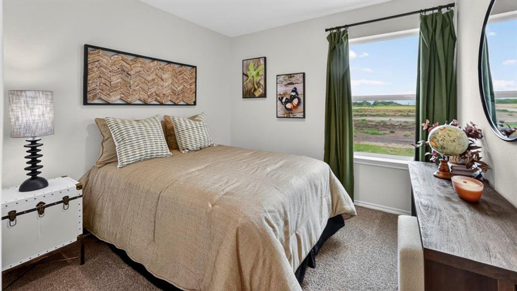 Bedroom featuring a window with a natural landscape, neutral wall tones, and carpeted flooring Bedroom featuring a window with a natural landscape, neutral wall tones, and carpeted flooring