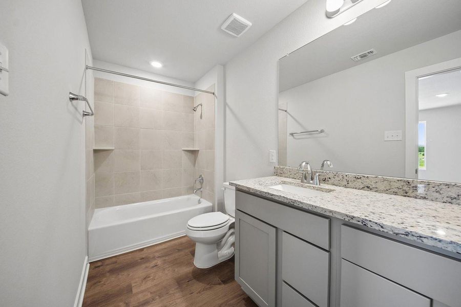 A well-appointed bath features a spacious vanity with stone counters and an integrated sink. A well-appointed bath features a spacious vanity with stone counters and an integrated sink.