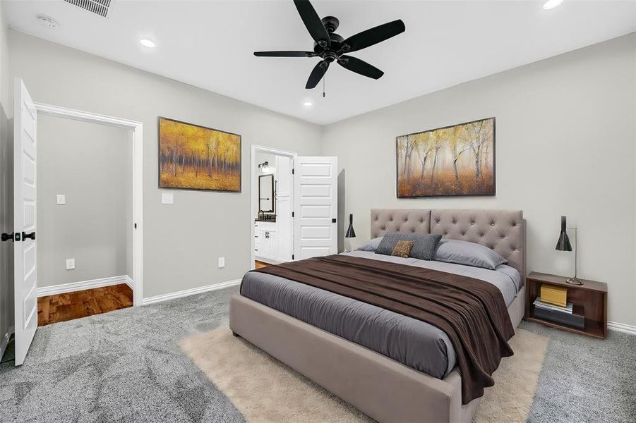 Bedroom featuring light carpet, ensuite bath, and ceiling fan