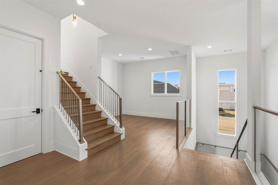 Crowning the second floor landing, a generously proportioned space accommodates a refined sitting area, offering a serene retreat bathed in natural light. Closed door is the elevator. Just beyond the stairs, a hallway leads to the second floor media room and also your second floor utility room. Crowning the second floor landing, a generously proportioned space accommodates a refined sitting area, offering a serene retreat bathed in natural light. Closed door is the elevator. Just beyond the stairs, a hallway leads to the second floor media room and also your second floor utility room.