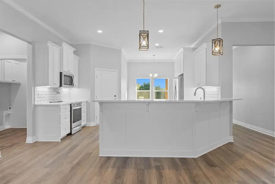Kitchen featuring decorative backsplash, hanging light fixtures, white cabinetry, ornamental molding, and recessed lighting