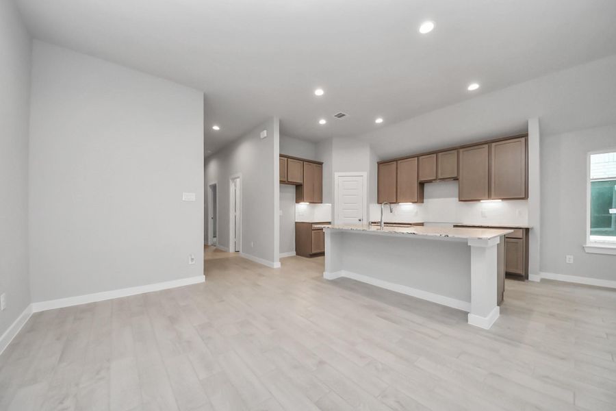 An inviting dining space seamlessly woven into the open concept, connecting the family room and kitchen. Sample photo of completed home with similar floor plan. Actual colors and selections may vary.