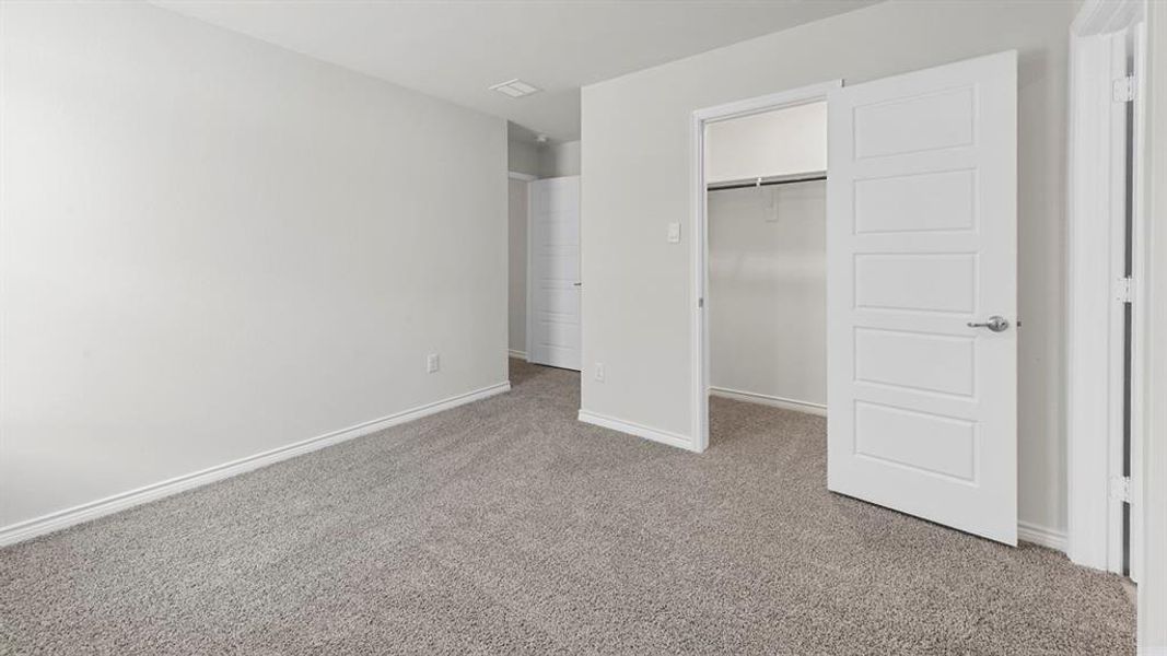 Unfurnished bedroom featuring carpet floors and a spacious closet