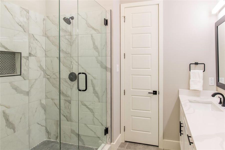 Bathroom featuring walk in shower, tile flooring, large vanity, and double sink