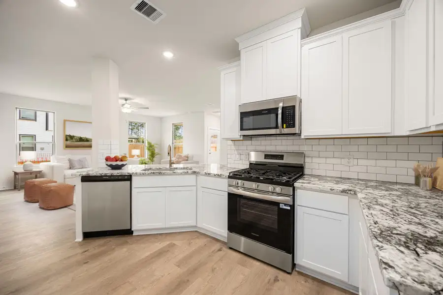 This beautifully designed kitchen showcases modern finishes and a functional layout. Bright white cabinetry and sleek countertops create a fresh, clean aesthetic, while stainless steel appliances add a contemporary touch. The open design provides seamless connection to the main living areas, making meal prep and everyday living effortless. Warm wood-style flooring enhances the inviting atmosphere, combining style and practicality in one elegant space. This beautifully designed kitchen showcases modern finishes and a functional layout. Bright white cabinetry and sleek countertops create a fresh, clean aesthetic, while stainless steel appliances add a contemporary touch. The open design provides seamless connection to the main living areas, making meal prep and everyday living effortless. Warm wood-style flooring enhances the inviting atmosphere, combining style and practicality in one elegant space.