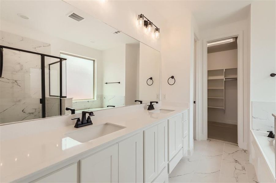 Bathroom featuring tile floors, double sink, plus walk in shower, and oversized vanity