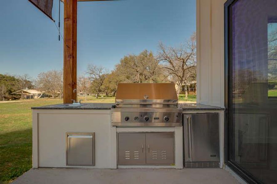 View of patio / terrace with an outdoor kitchen and a sink