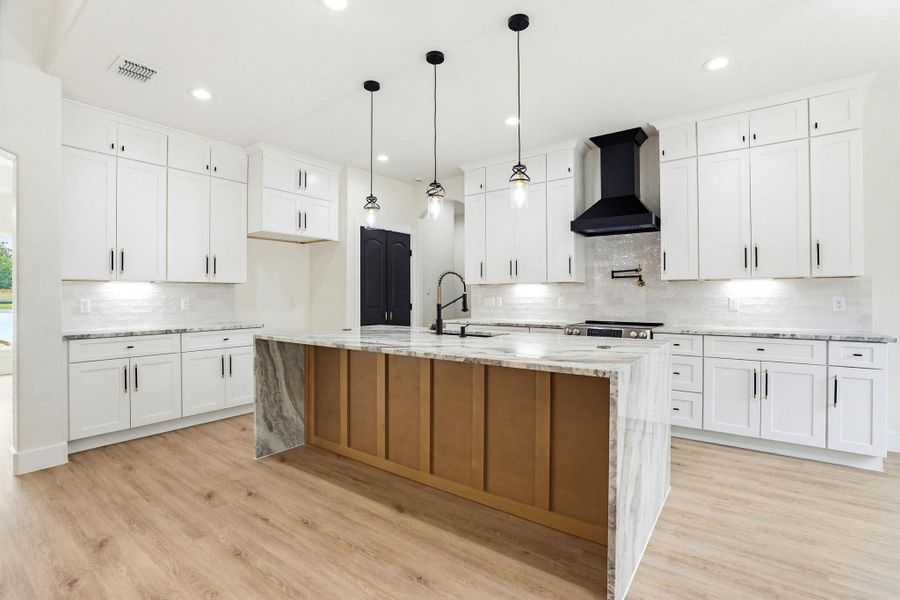 A chef's dream, this kitchen boasts an oversized island, ample cabinetry, and sleek finishes throughout.