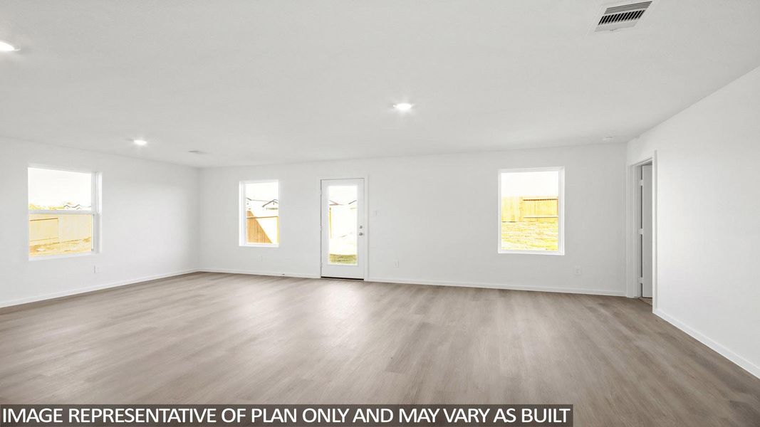 Spacious room featuring light wood-finish flooring, recessed lighting, and white painted walls