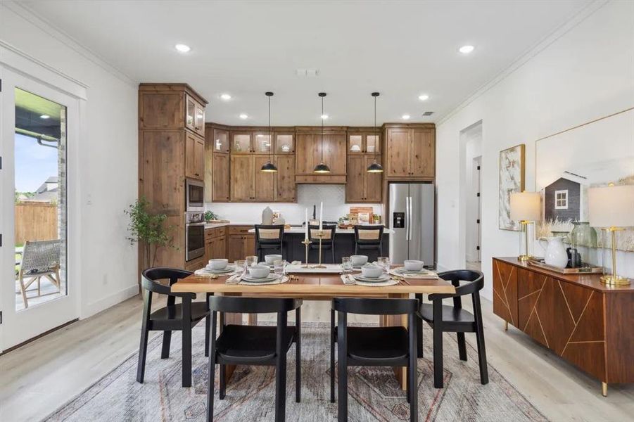 Dining space with light wood-style floors, recessed lighting, and ornamental molding