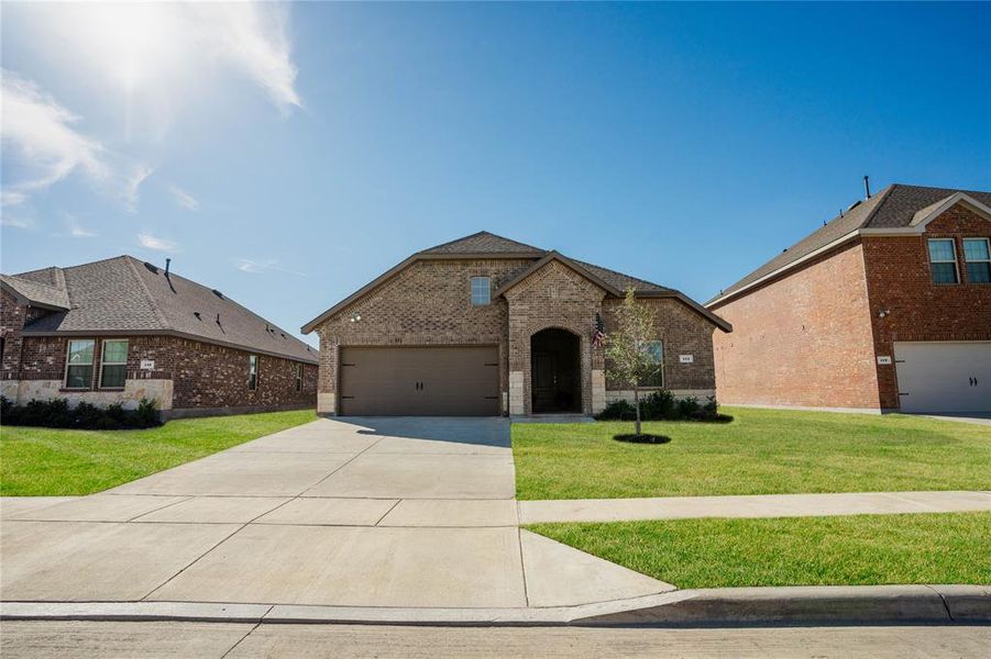 View of front of property with a garage and a front lawn