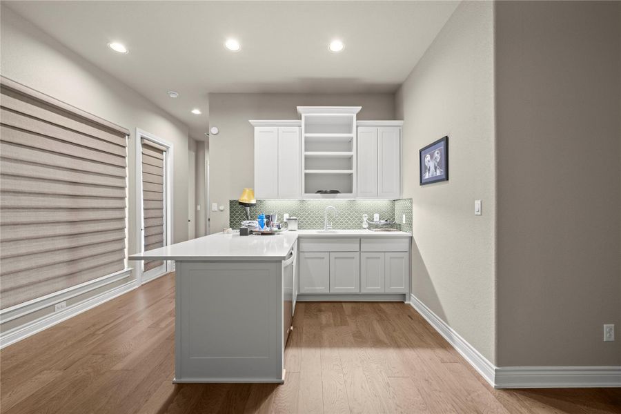 A streamlined kitchen island anchors this functional space with rich hardwood flooring and sleek cabinetry. A streamlined kitchen island anchors this functional space with rich hardwood flooring and sleek cabinetry.