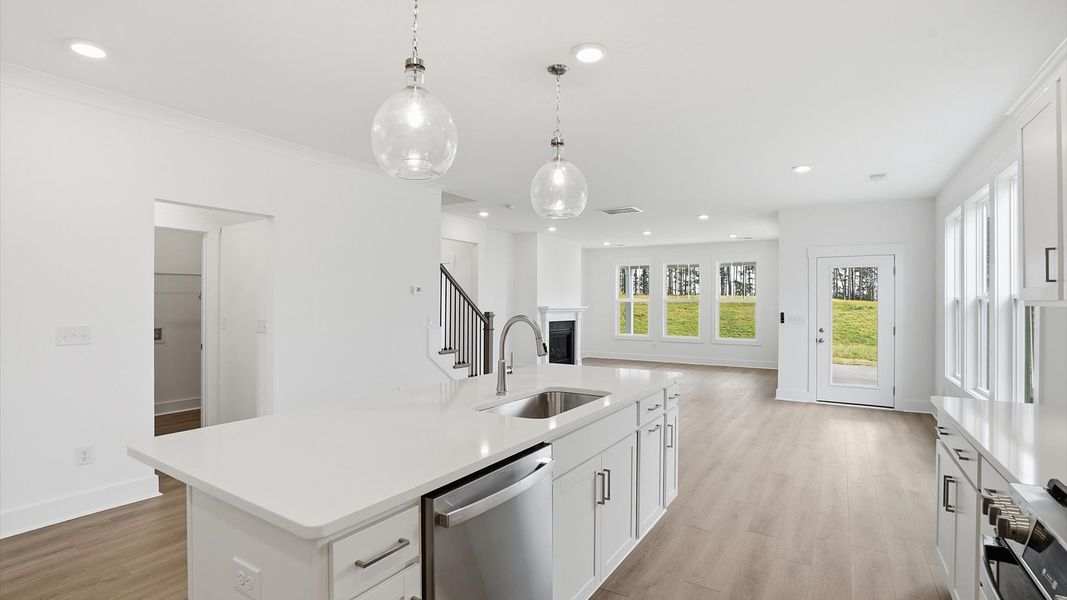 Highly skilled craftsmanship shines in this modern kitchen with pendant lighting and a central island focal point