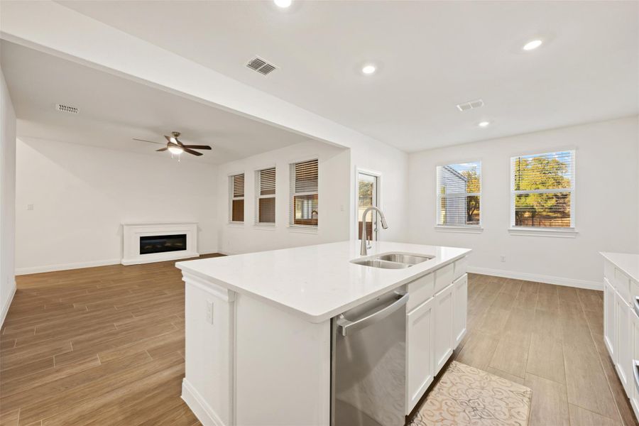 Kitchen featuring wood finish floors, dishwasher, a kitchen island with sink, recessed lighting, and open floor plan Kitchen featuring wood finish floors, dishwasher, a kitchen island with sink, recessed lighting, and open floor plan