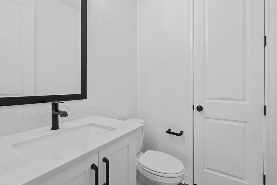 Half bathroom featuring vanity and toilet Half bathroom featuring vanity and toilet
