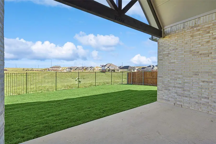 Fenced backyard featuring a patio and a residential view