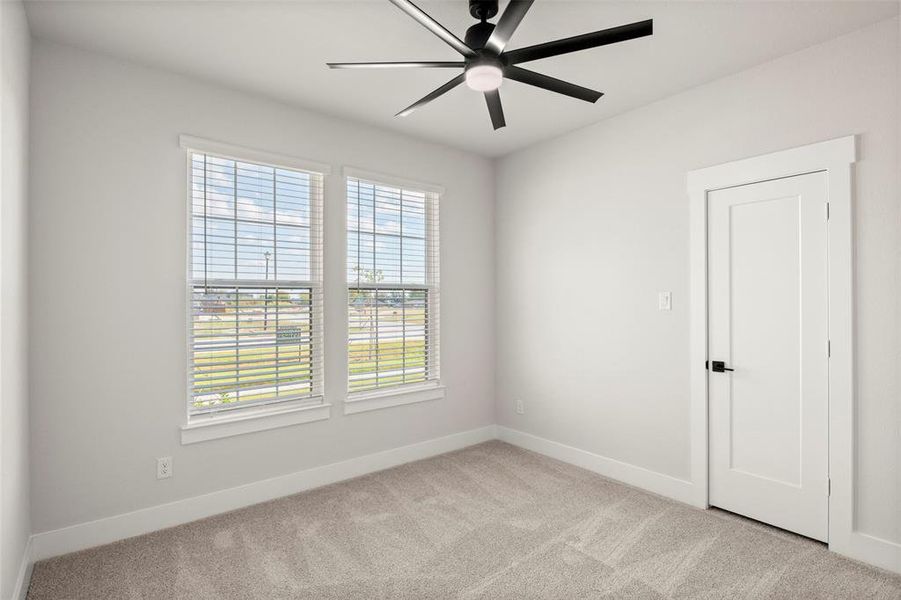 Unfurnished room with light colored carpet and a ceiling fan