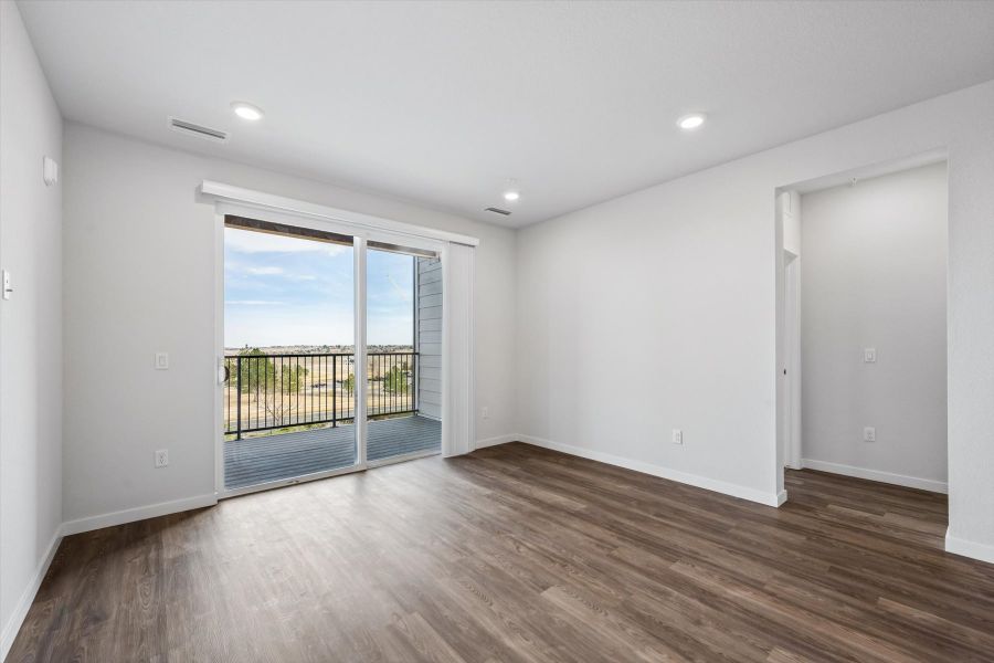 A room with a wood floor and a wood floor with a glass door.