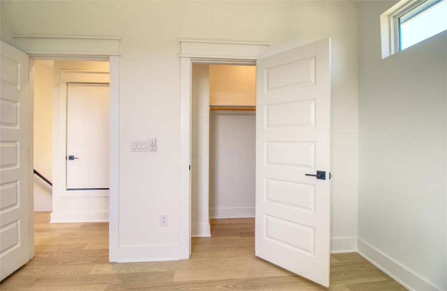 Unfurnished bedroom with light wood-style floors and a spacious closet