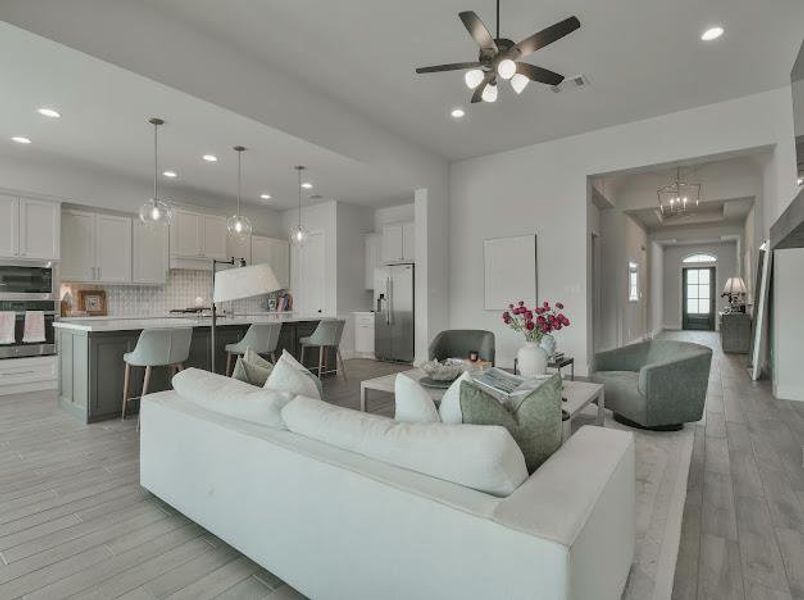 Living room with light wood-type flooring, recessed lighting, a ceiling fan, and a chandelier Living room with light wood-type flooring, recessed lighting, a ceiling fan, and a chandelier