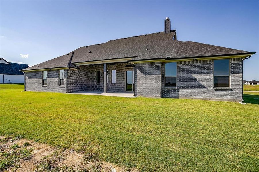 Back of house with a patio and a lawn