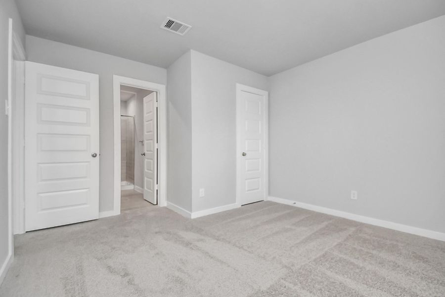 Inviting guest suite adorned with modern charm. The room features elegant 5-panel doors with sleek, contemporary hardware that adds a touch of sophistication. Sink your feet into the plush, fluffy carpet that invites comfort and warmth. Sample photo of completed home with similar floor plan. Actual colors and selections may vary.