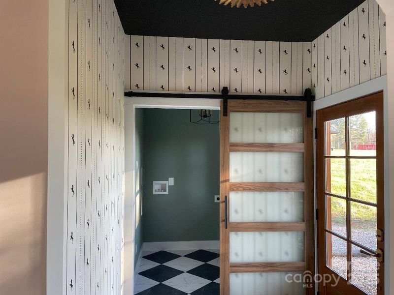 Mud room entry from back porch and spacious laundry room with special feature of barn door