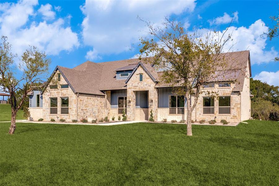 View of front of property featuring stone siding and a front yard View of front of property featuring stone siding and a front yard