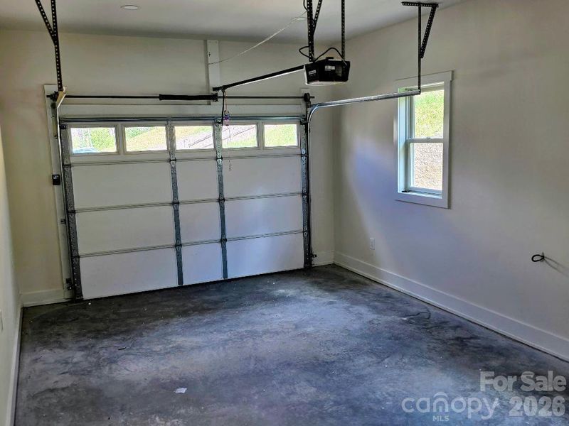 Garage with electric opener for the door; it is prewired for an electric car charger
