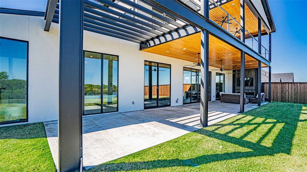 Rear view of property featuring ceiling fan, a yard, a patio, and a pergola