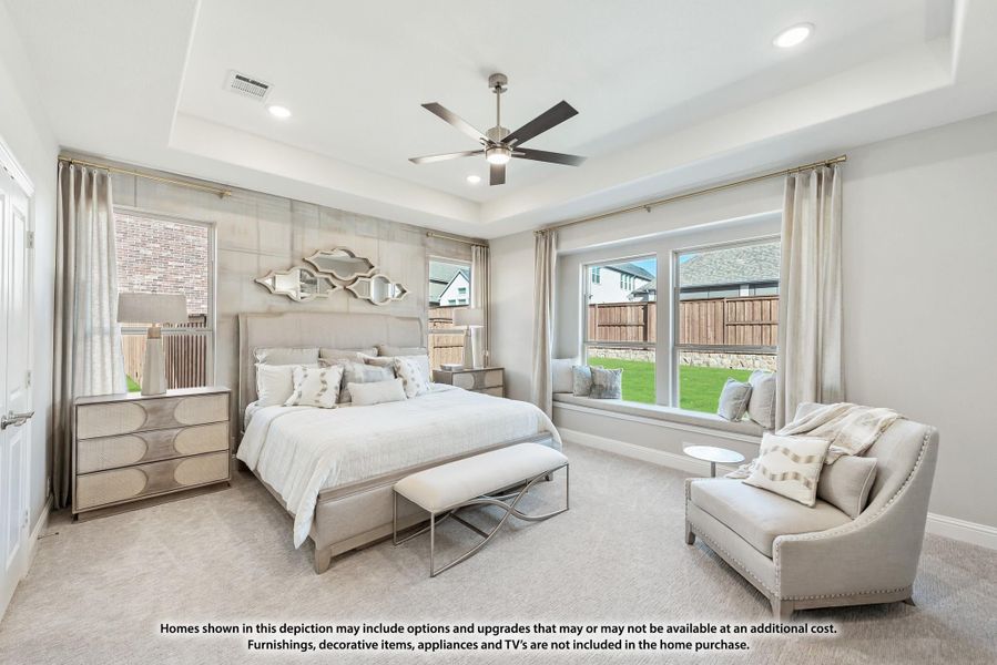 Master bedroom with tray ceiling, ceiling fan, window seat, and neutral carpet flooring Master bedroom with tray ceiling, ceiling fan, window seat, and neutral carpet flooring
