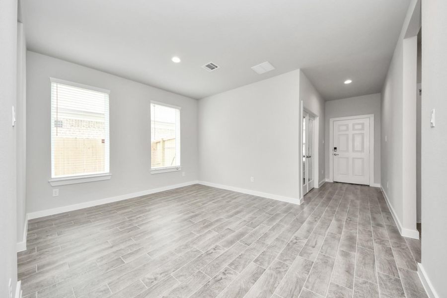 Create lasting memories with your family and friends at the dining table! This expansive dining room showcases sophisticated flooring, custom paint, and seamlessly connects to the family room and kitchen, providing an open and inviting atmosphere. Sample photo of completed home with similar floor plan. Actual colors and selections may vary.