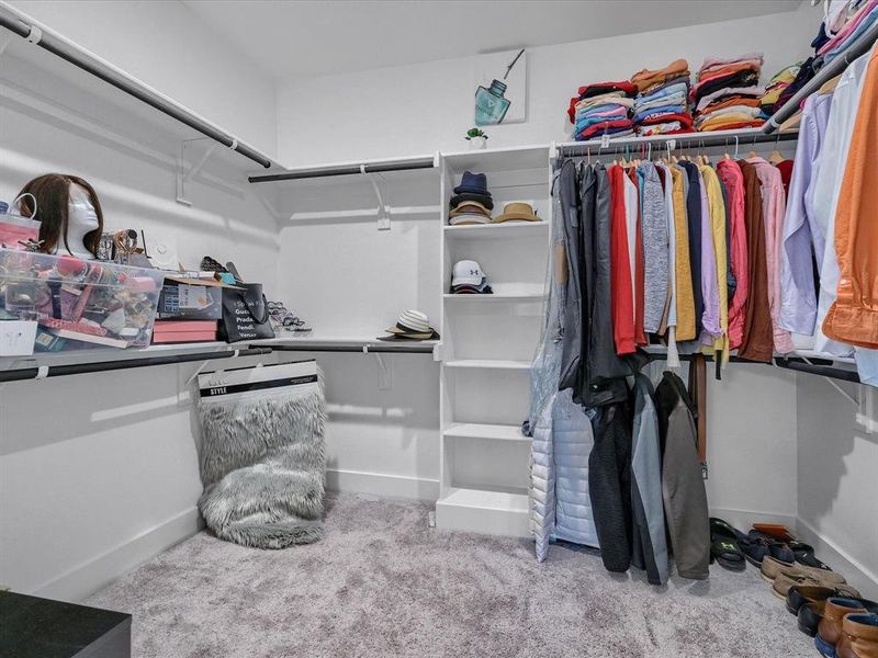 Walk in closet featuring light colored carpet Walk in closet featuring light colored carpet