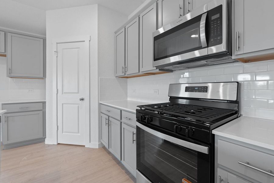Kitchen with gray cabinets and appliances with stainless steel finishes Kitchen with gray cabinets and appliances with stainless steel finishes