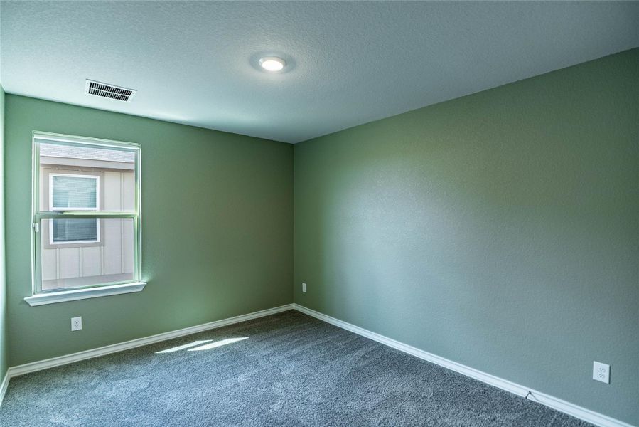 Unfurnished room featuring carpet floors and a textured ceiling Unfurnished room featuring carpet floors and a textured ceiling