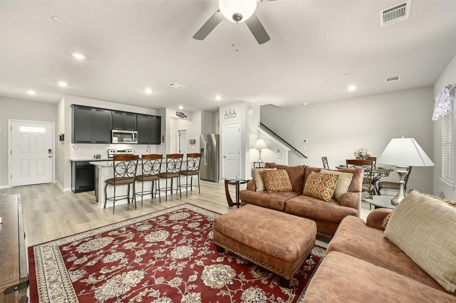 Living room with ceiling fan and light hardwood / wood-style flooring